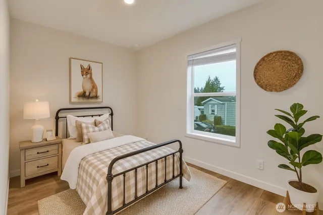 a bedroom with a bed a mirror and a potted plant
