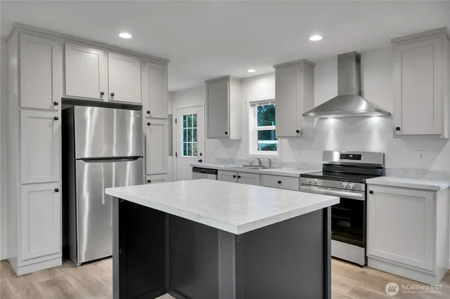 a kitchen with a stove a refrigerator and a sink