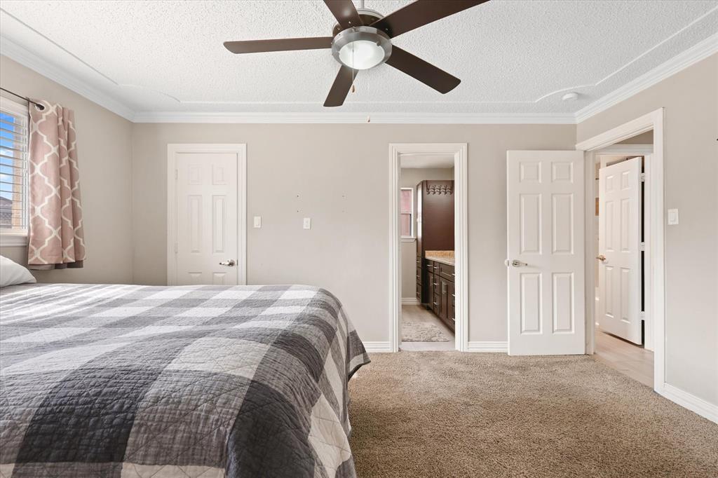 7636 Castillo Road Fort Worth, TX 76112 - Photo 13 of 28 a bedroom with a bed and a chandelier fan