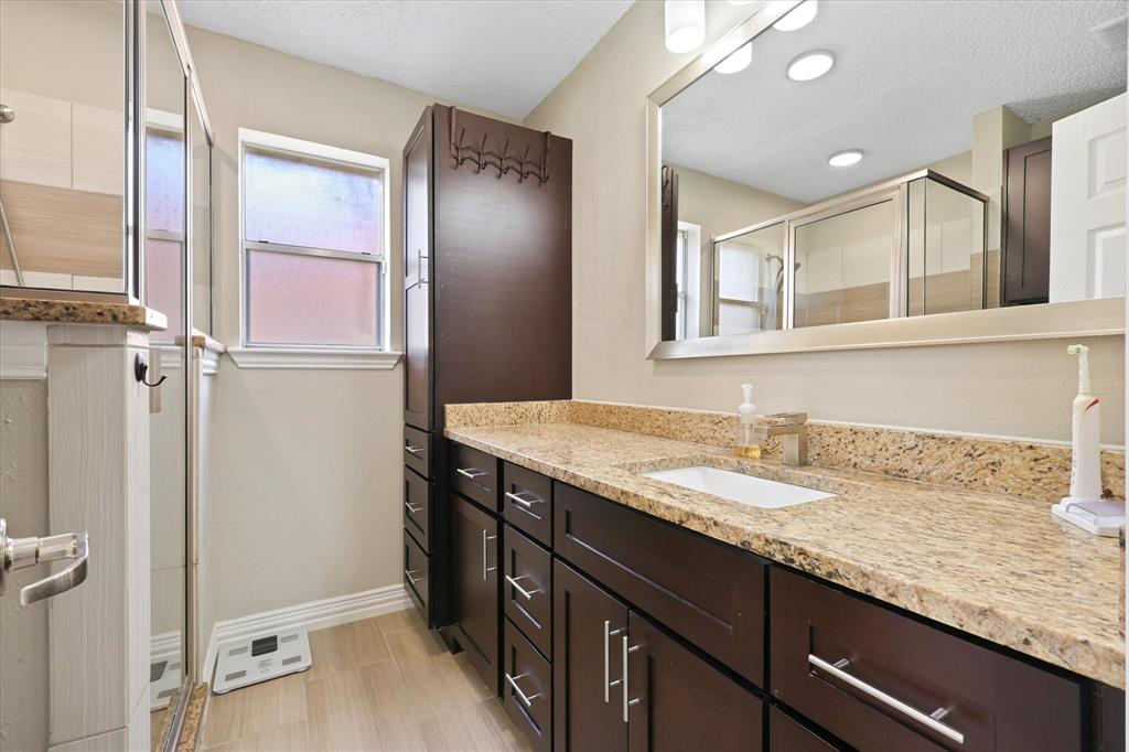 7636 Castillo Road Fort Worth, TX 76112 - Photo 14 of 28 a bathroom with a granite countertop sink and a mirror