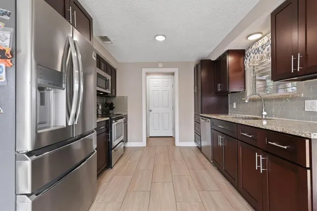 a kitchen with stainless steel appliances a refrigerator and a sink