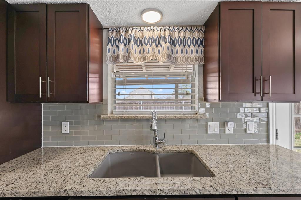 7636 Castillo Road Fort Worth, TX 76112 - Photo 9 of 28 a kitchen with granite countertop a sink and a window