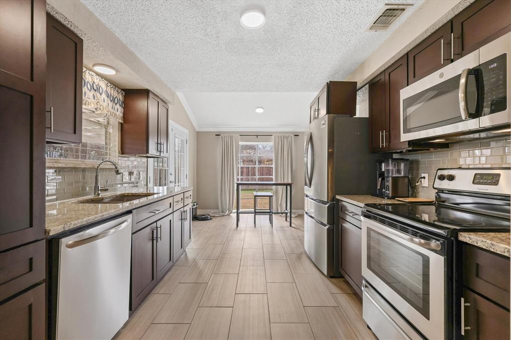 7636 Castillo Road Fort Worth, TX 76112 - Photo 10 of 28 a kitchen with stainless steel appliances granite countertop a stove and a sink