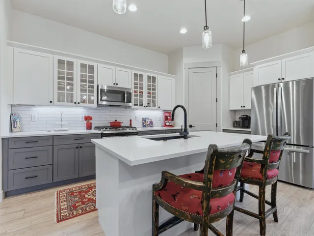 a kitchen with granite countertop a sink cabinets and stainless steel appliances