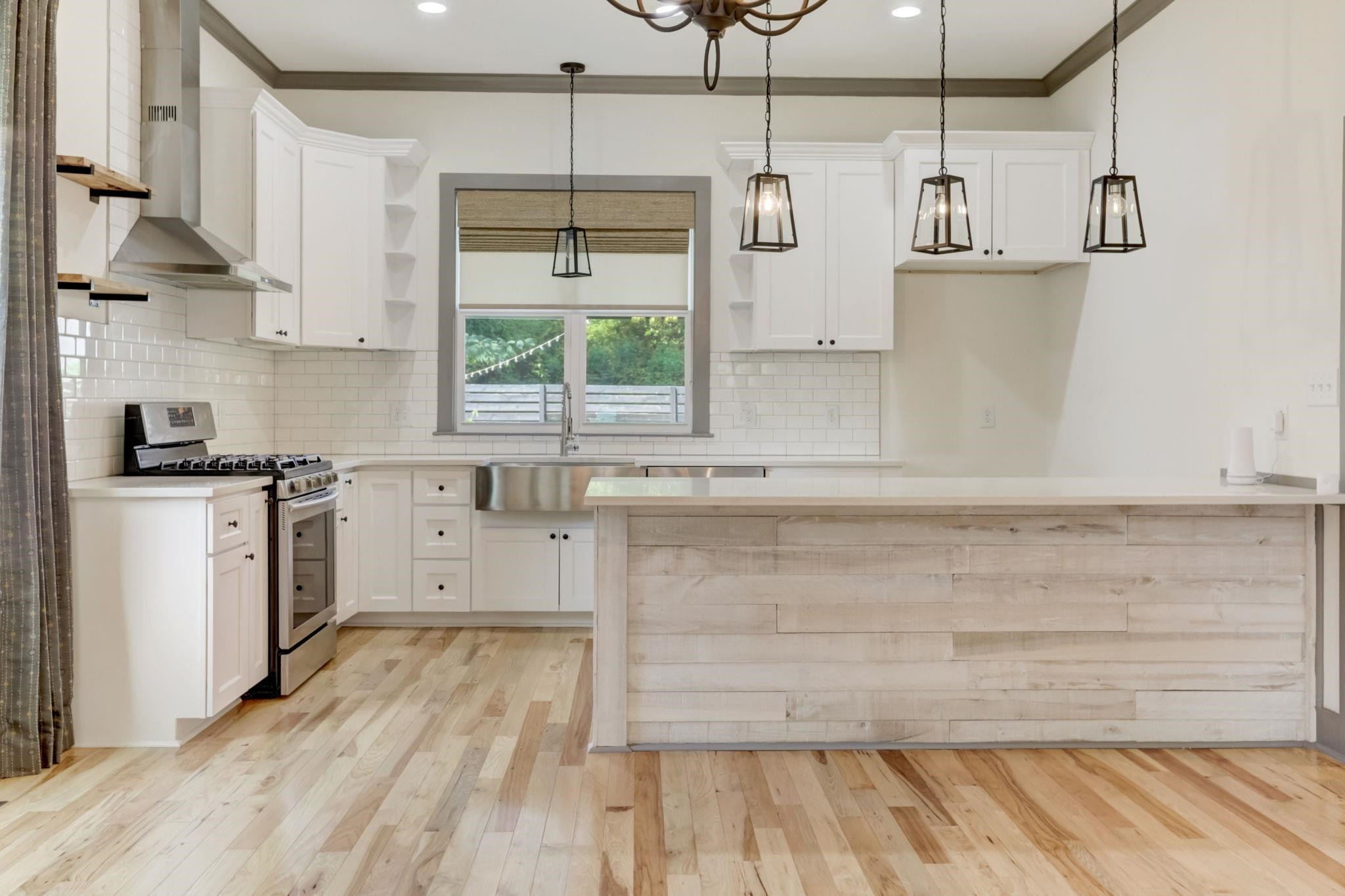 7 Hill Street Raleigh, NC 27610 - Photo 8 of 25 a kitchen with stainless steel appliances a stove and white cabinets with wooden floor