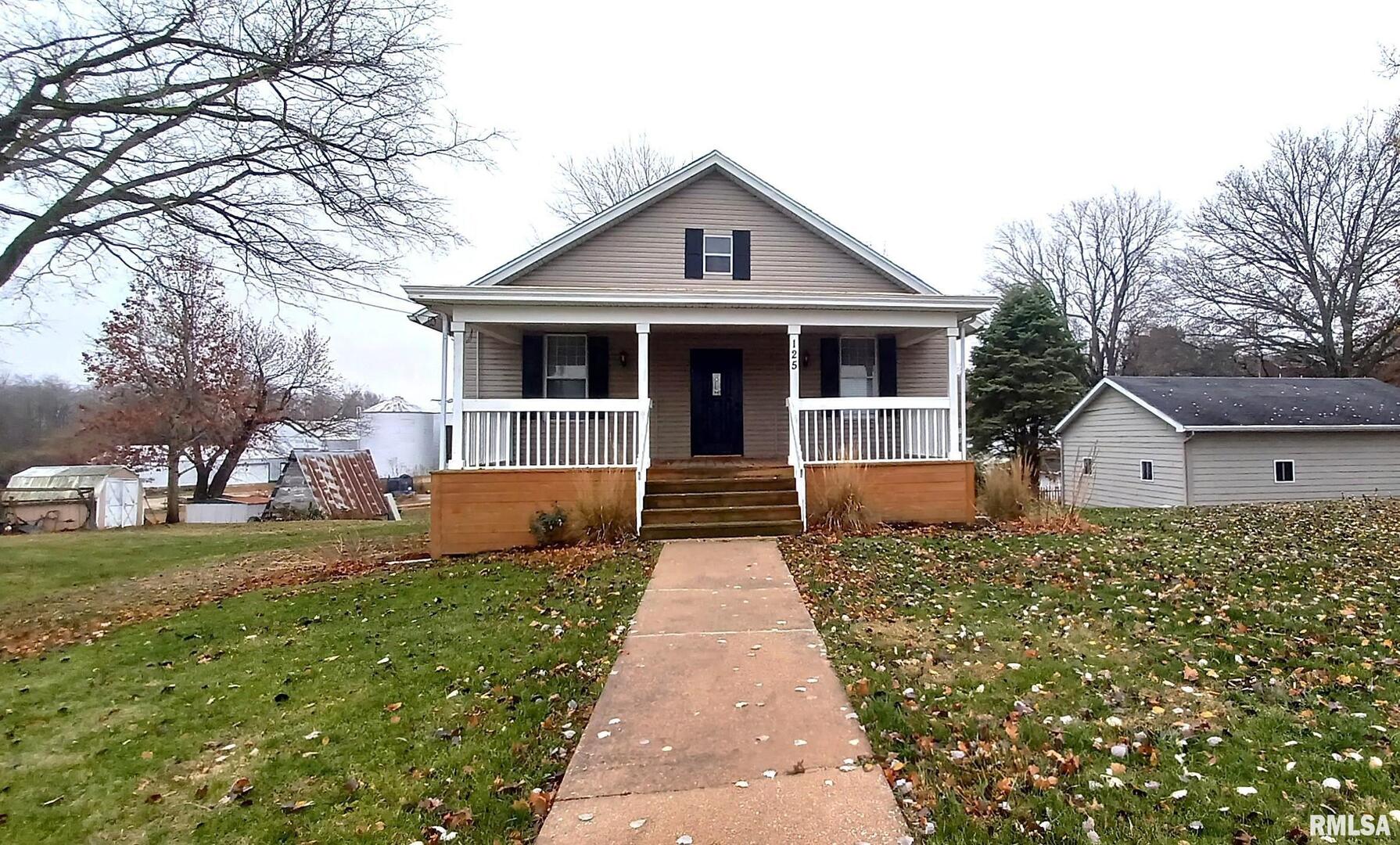 125 A Street Buda, IL 61314 - Photo 3 of 29 a front view of a house with a yard and trees