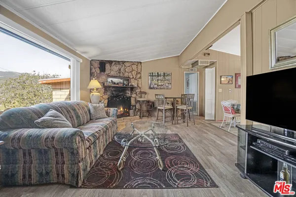 a living room with furniture fireplace and a large window