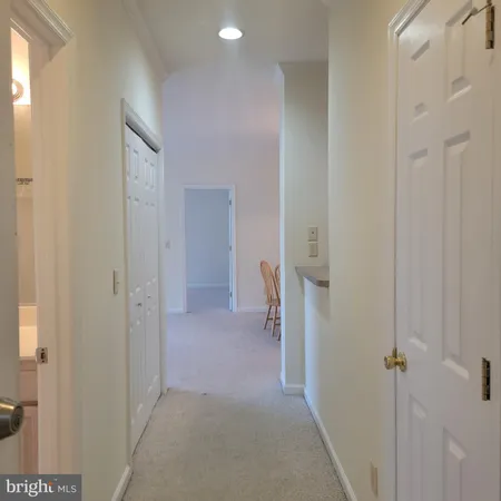 a view of a hallway with closet and a bathroom