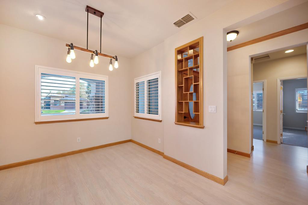 9594 Prost Court Elk Grove, CA 95758 - Photo 13 of 46 a view of an empty room with a window and wooden floor