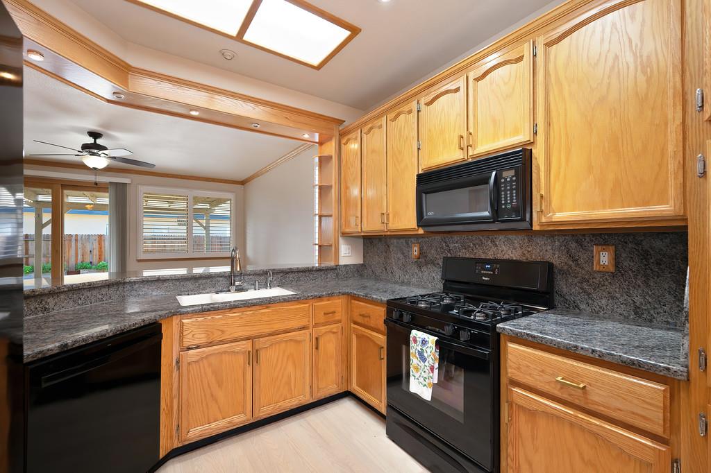 9594 Prost Court Elk Grove, CA 95758 - Photo 15 of 46 a kitchen with granite countertop cabinets stainless steel appliances a sink and a window