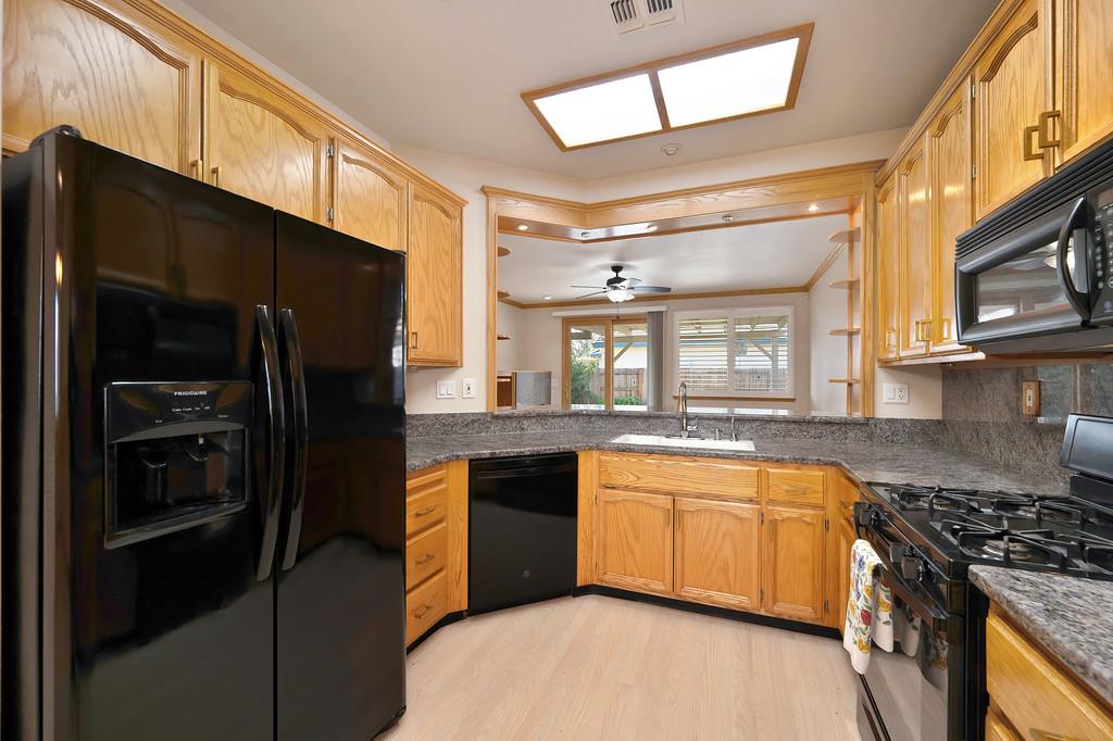 9594 Prost Court Elk Grove, CA 95758 - Photo 16 of 46 a kitchen with stainless steel appliances granite countertop a stove a refrigerator and a sink