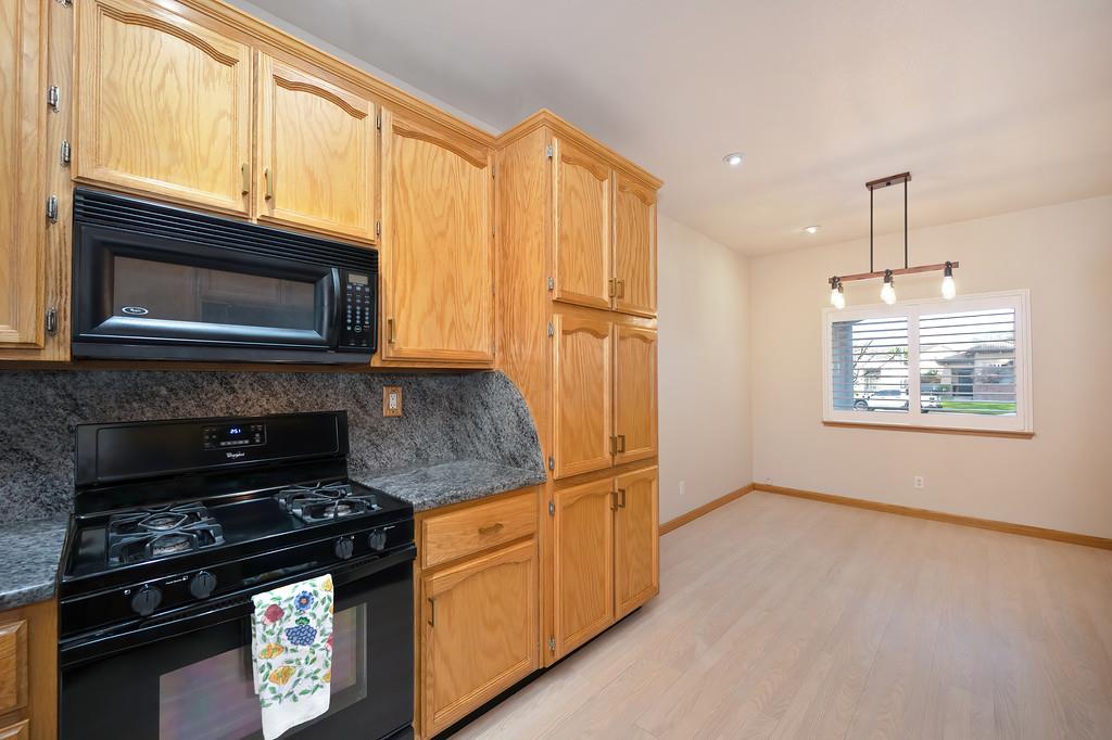 9594 Prost Court Elk Grove, CA 95758 - Photo 18 of 46 a kitchen with granite countertop cabinets stainless steel appliances and a window