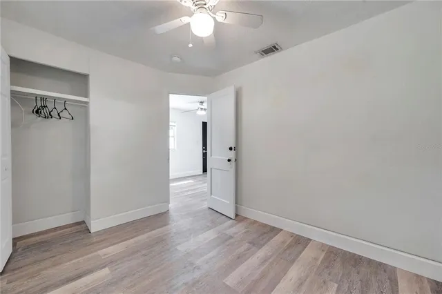 a view of an empty room with wooden floor