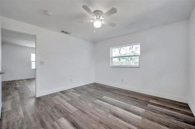 wooden floor in an empty room with a window