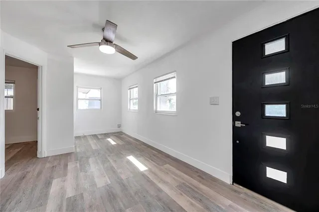 a view of an empty room window and wooden floor