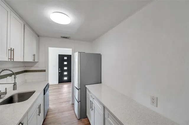a kitchen with granite countertop a sink and cabinets