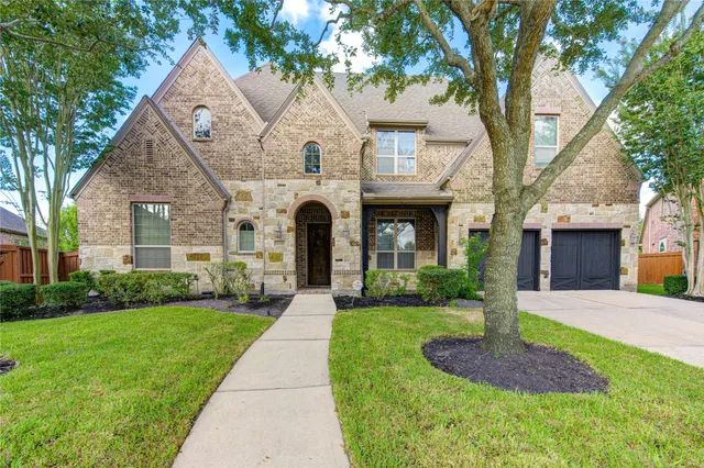a front view of a house with a yard and trees