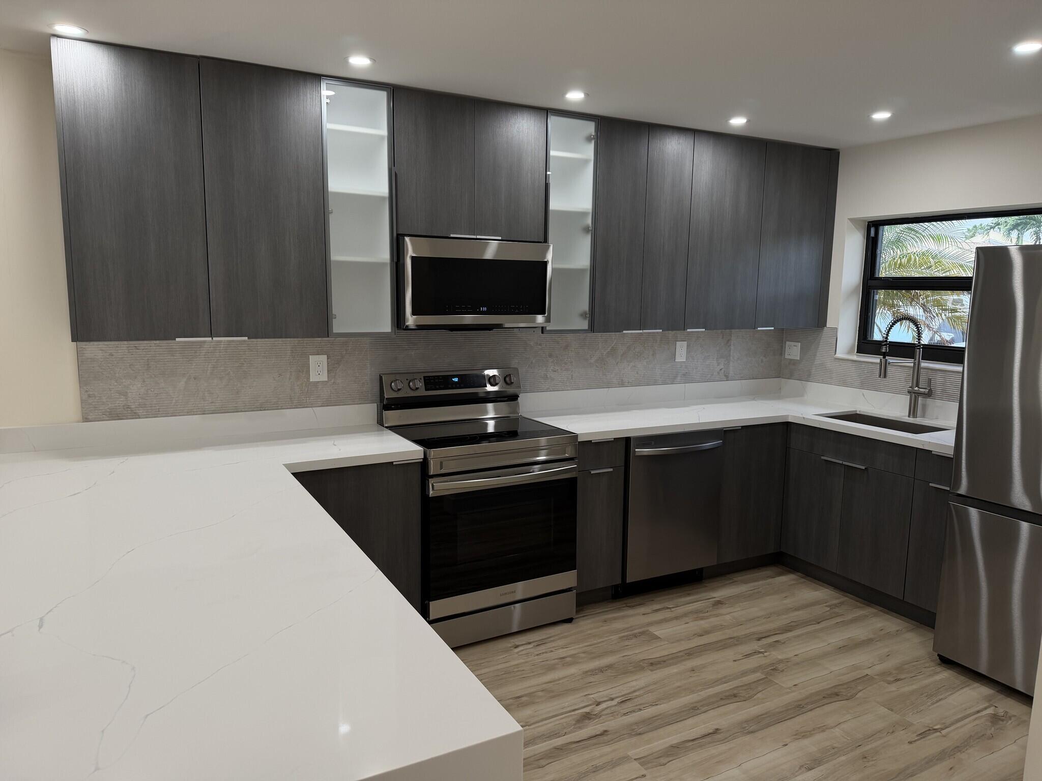 a kitchen with stainless steel appliances granite countertop a stove a sink and a microwave