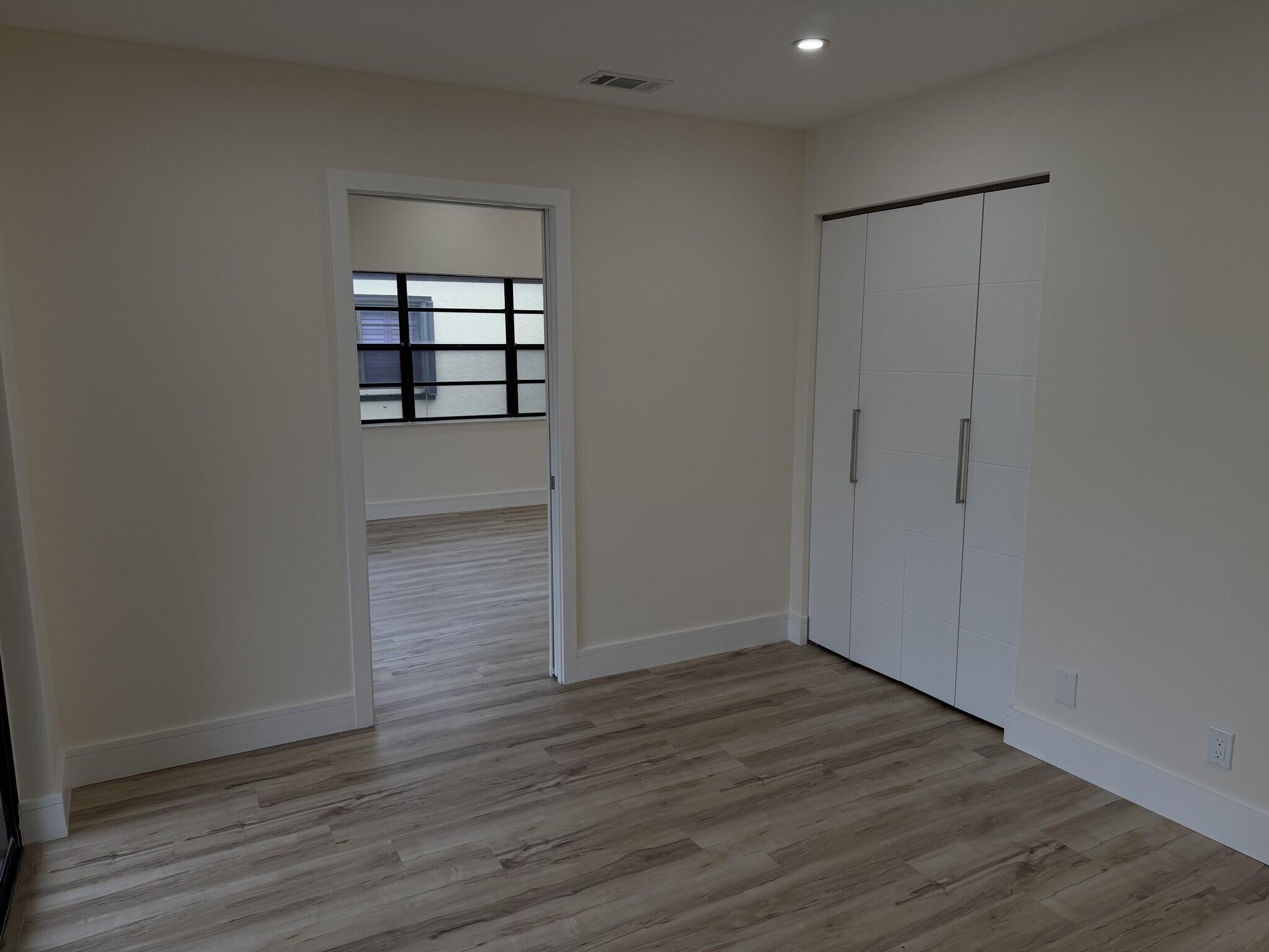 705 Banks Road Margate, FL 33063 - Photo 13 of 44 an empty room with wooden floor cabinet and windows