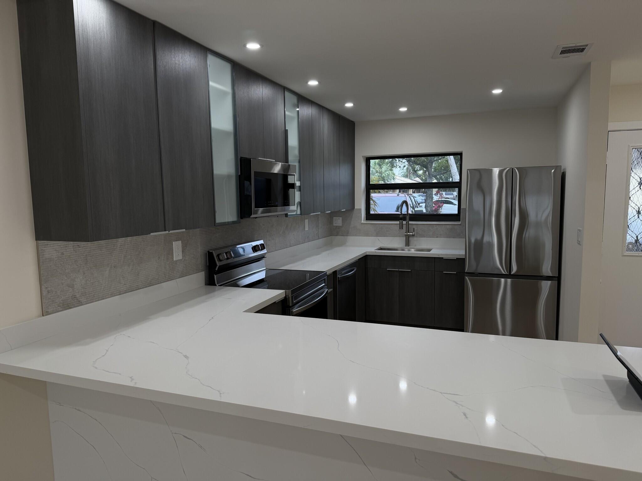 705 Banks Road Margate, FL 33063 - Photo 2 of 44 a kitchen with stainless steel appliances a refrigerator and a sink