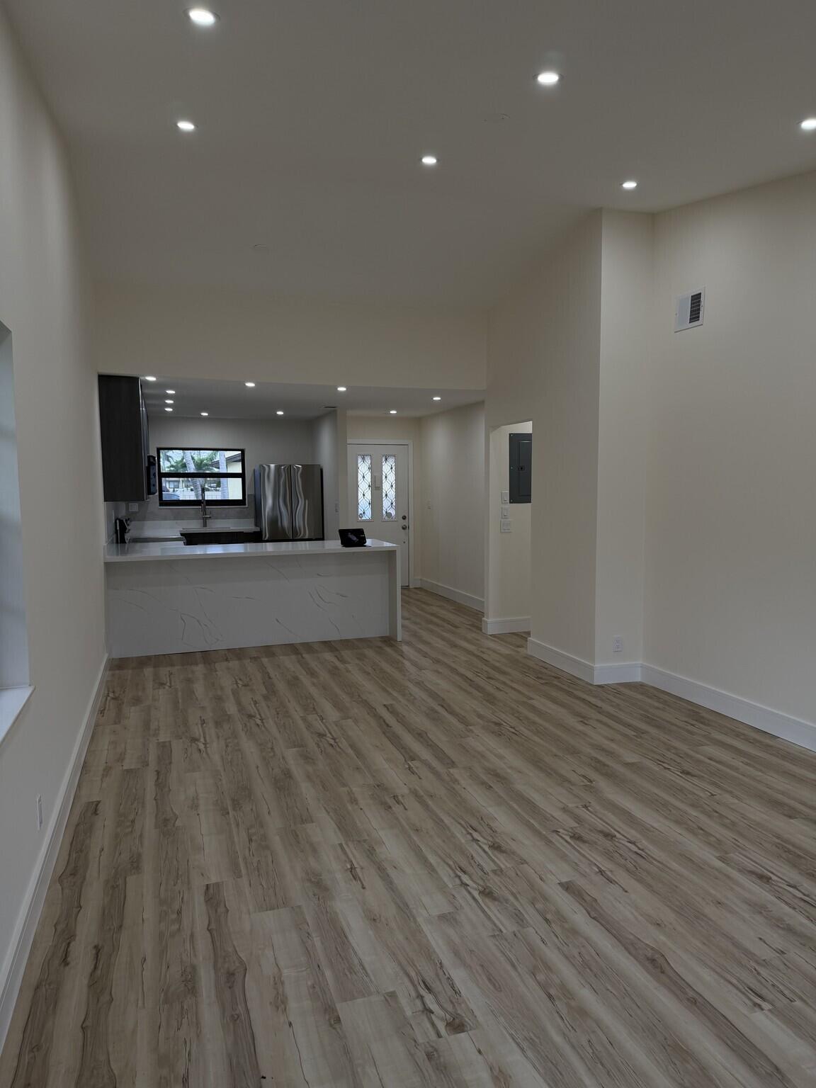 705 Banks Road Margate, FL 33063 - Photo 7 of 44 a view of a big room with wooden floor and windows