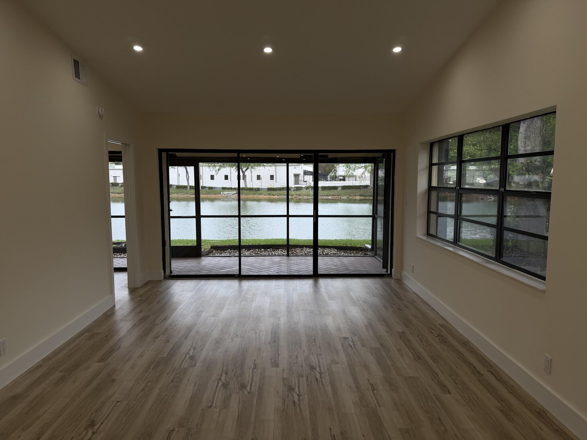 705 Banks Road Margate, FL 33063 - Photo 10 of 44 an empty room with wooden floor and windows