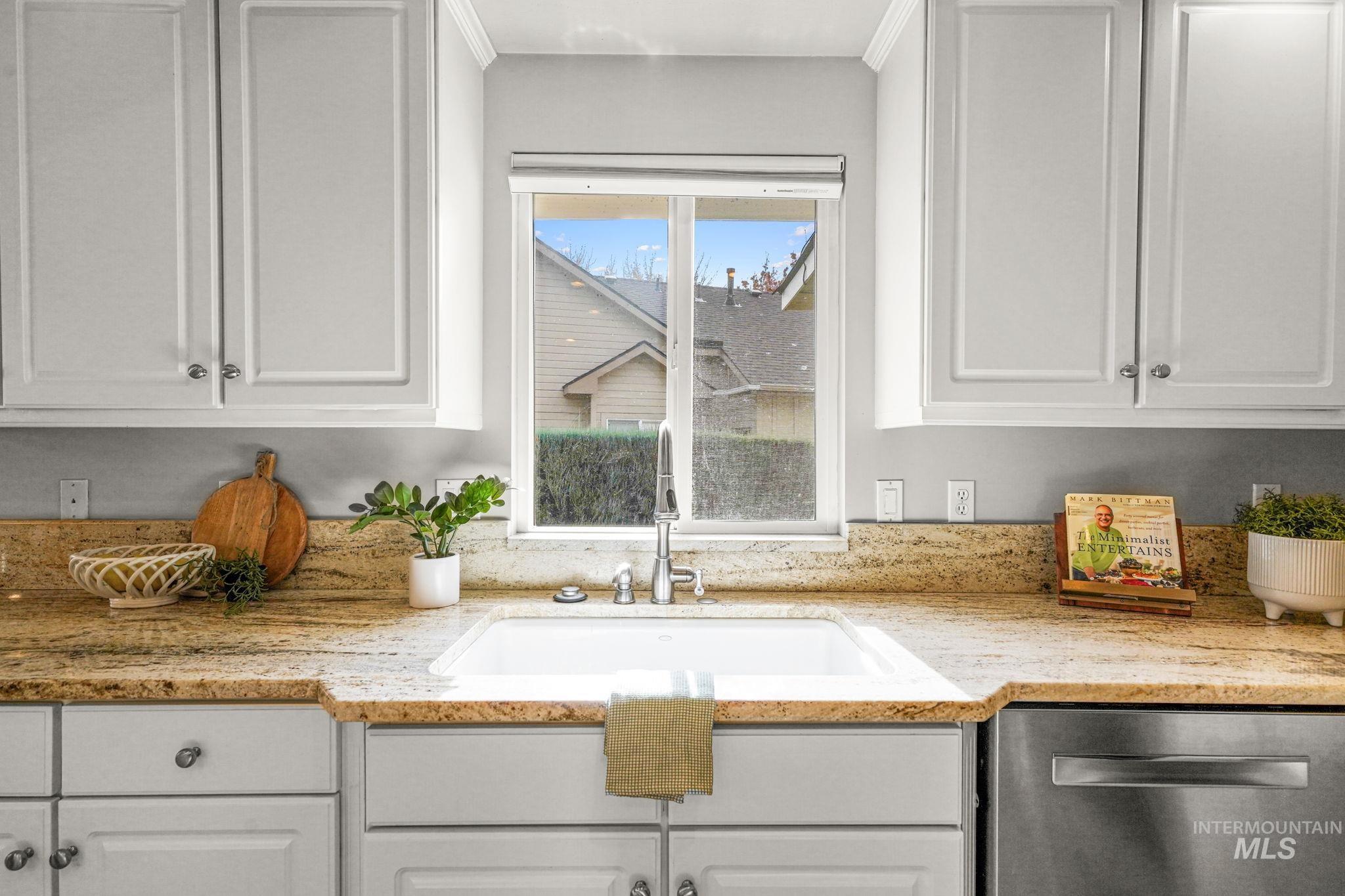5790 North Wellspring Way Boise, ID 83713 - Photo 13 of 41 Kitchen featuring white cabinetry, dishwasher, and light stone countertops