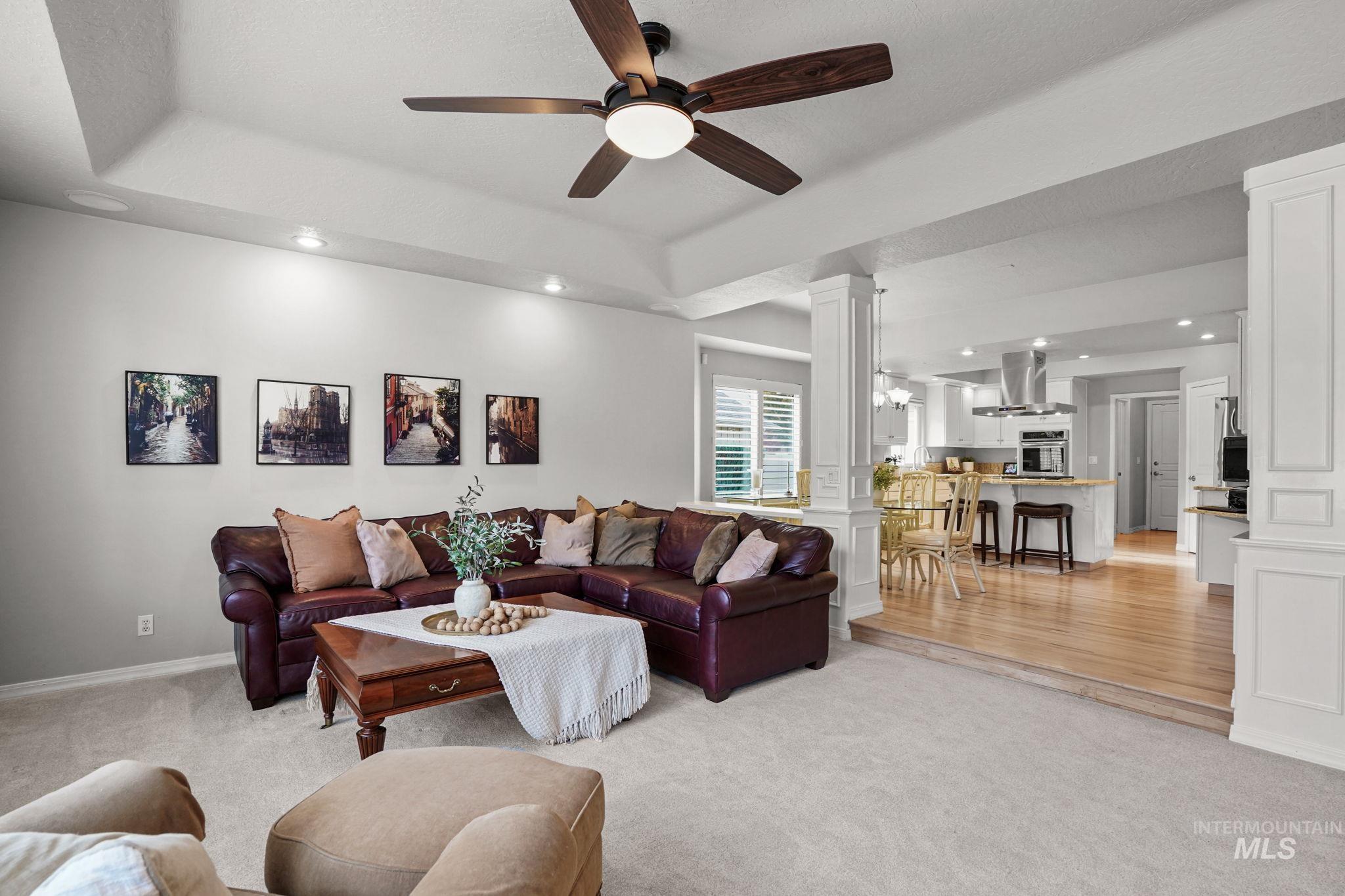 5790 North Wellspring Way Boise, ID 83713 - Photo 17 of 41 Living area featuring decorative columns, a tray ceiling, recessed lighting, light colored carpet, and ceiling fan