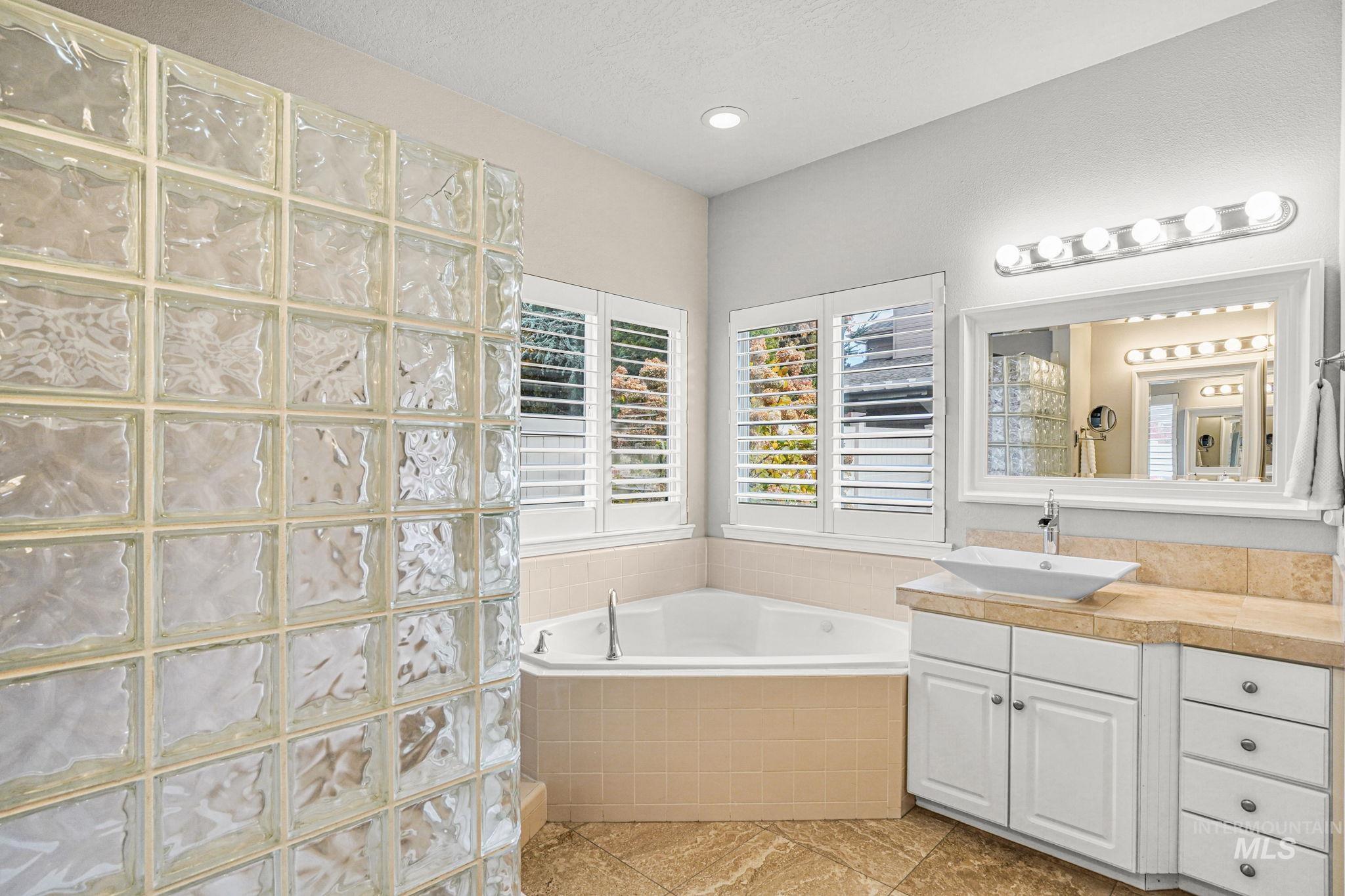 5790 North Wellspring Way Boise, ID 83713 - Photo 20 of 41 Full bath featuring vanity, a garden tub, light tile patterned floors, and a walk in shower