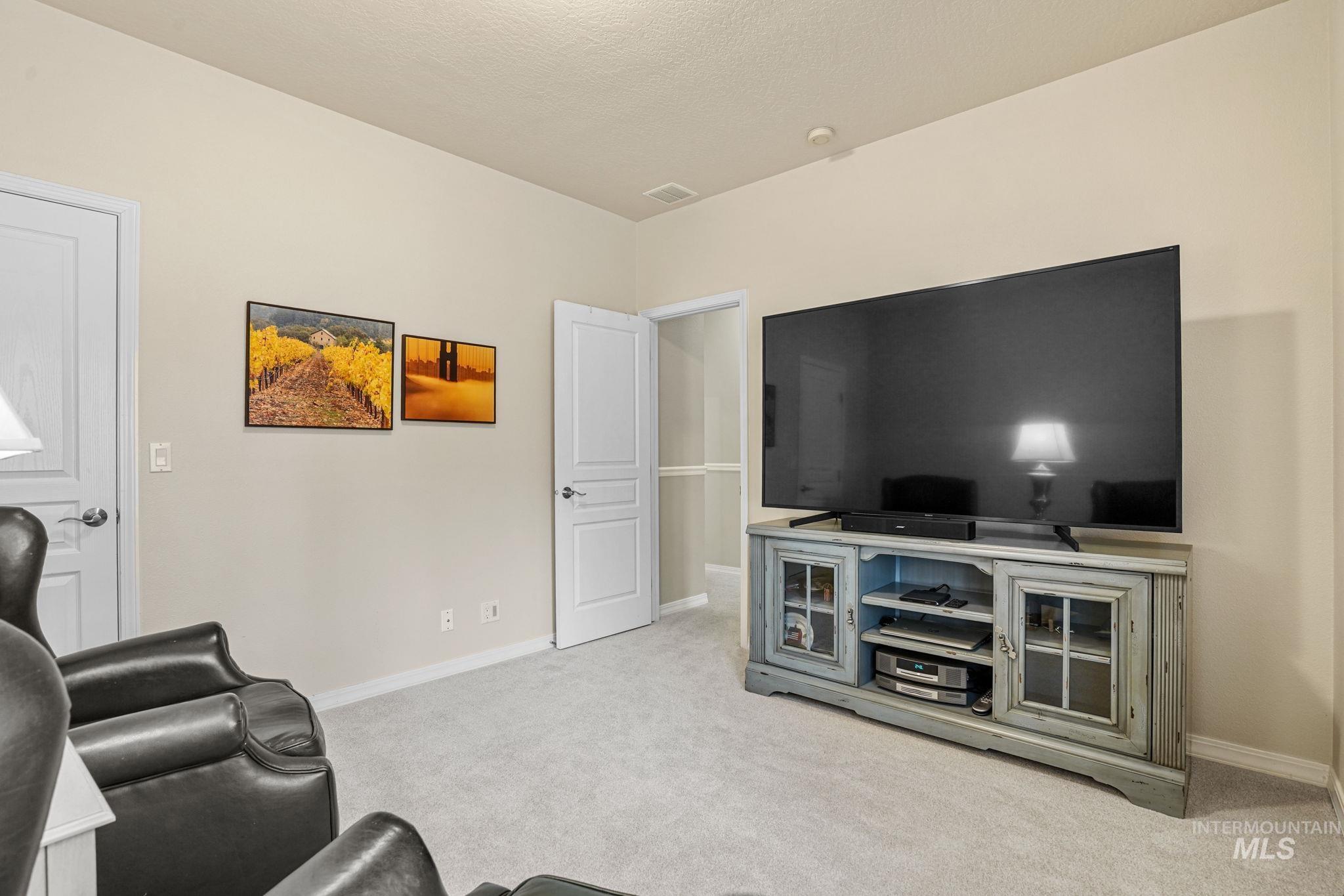 5790 North Wellspring Way Boise, ID 83713 - Photo 28 of 41 Living room with light colored carpet and baseboards