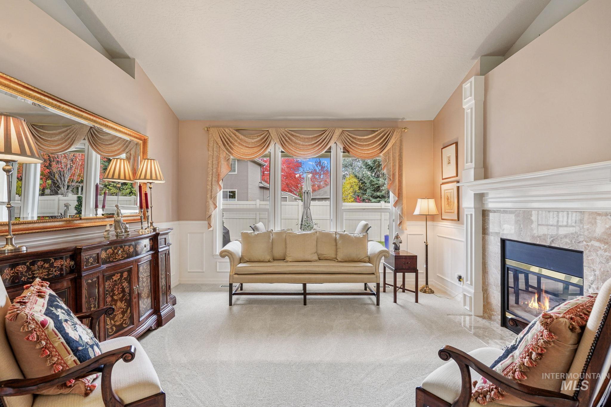 5790 North Wellspring Way Boise, ID 83713 - Photo 30 of 41 Living room with carpet flooring, a decorative wall, a high end fireplace, and wainscoting