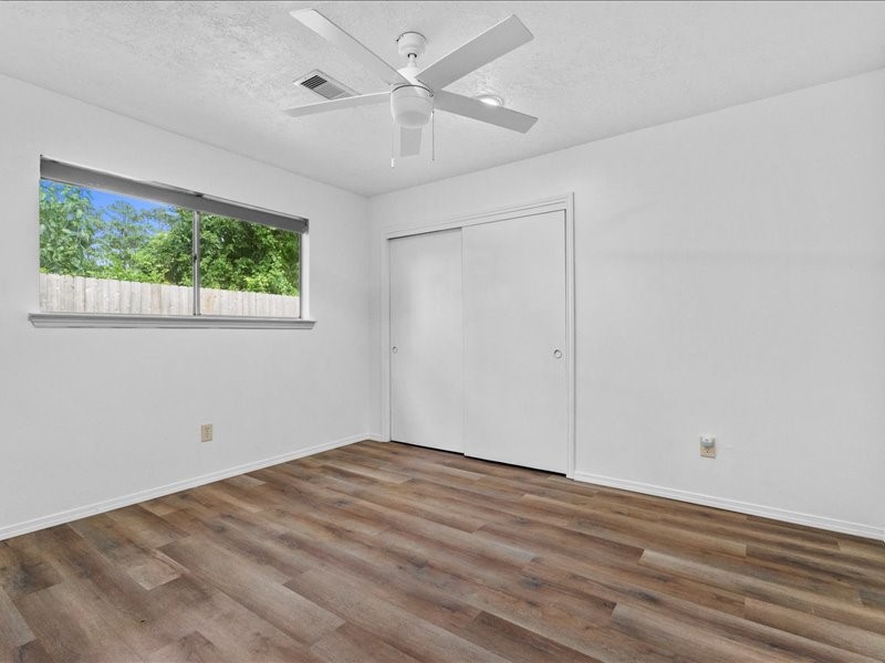 6631 Ambler Drive Spring, TX 77379 - Photo 27 of 37 an empty room with wooden floor chandelier fan and windows