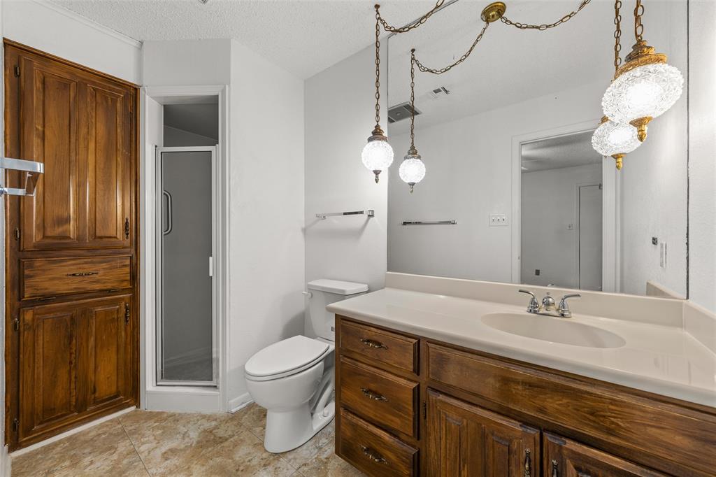 7821 Tallahassee Road Woodway, TX 76712 - Photo 18 of 31 a bathroom with a granite countertop sink a toilet and a mirror