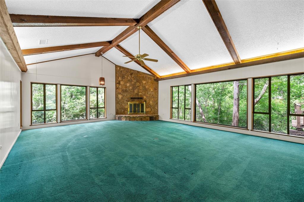 7821 Tallahassee Road Woodway, TX 76712 - Photo 4 of 31 a view of an empty room with a fireplace and windows