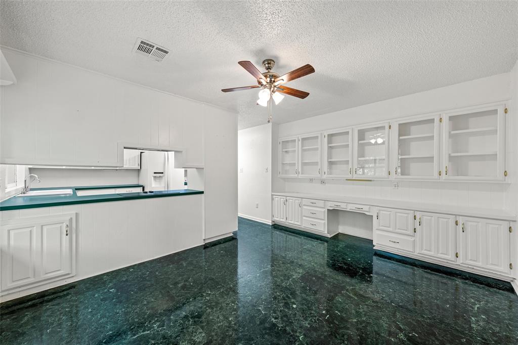 7821 Tallahassee Road Woodway, TX 76712 - Photo 9 of 31 a kitchen with granite countertop white cabinets and a sink