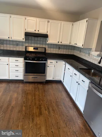 a kitchen with granite countertop a stove a sink and a granite counter tops