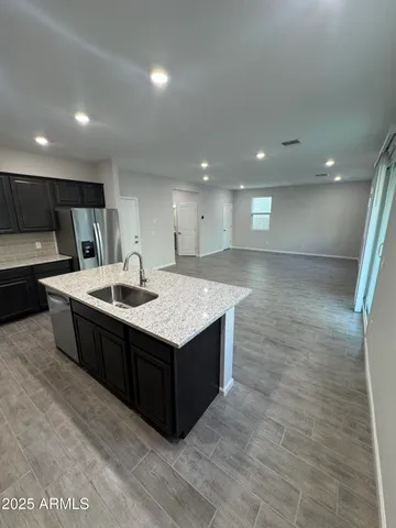 a large kitchen with stainless steel appliances a sink and a refrigerator