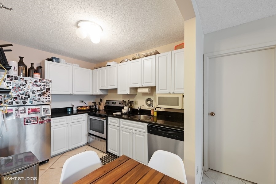 111 West Maple Street, Unit 2611 Chicago, IL 60610 - Photo 6 of 11 a kitchen with a sink stove and cabinets