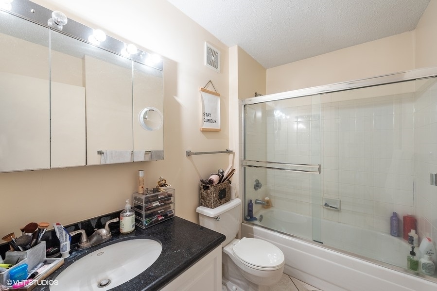 111 West Maple Street, Unit 2611 Chicago, IL 60610 - Photo 8 of 11 a bathroom with a sink a toilet and shower