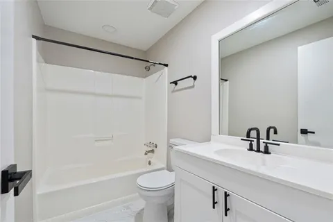 a bathroom with a sink a toilet a mirror a bathtub and shower