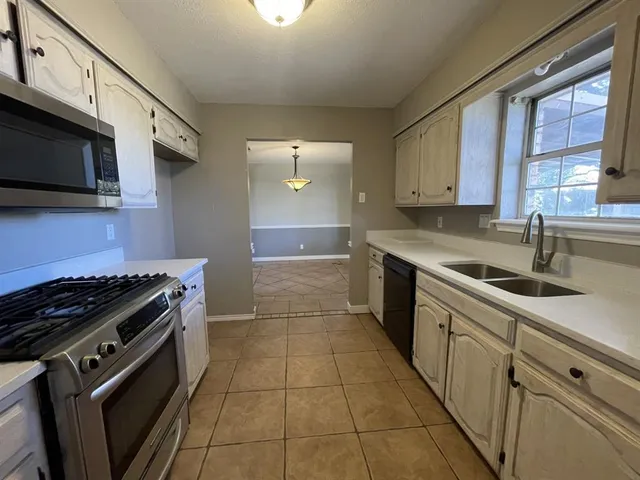 a kitchen with stainless steel appliances granite countertop a sink stove and cabinets