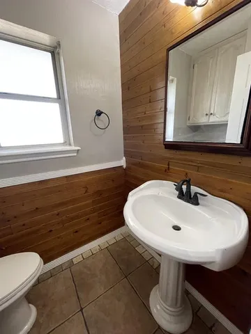 a bathroom with a sink a toilet and mirror