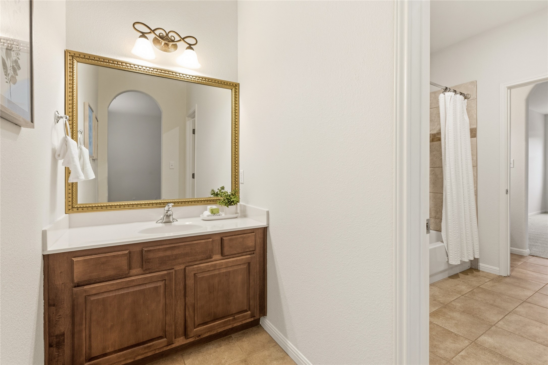 1432 Tom Sawyer Road Austin, TX 78737 - Photo 27 of 33 A traditional wood vanity with a white countertop enhances this functional bathroom space.