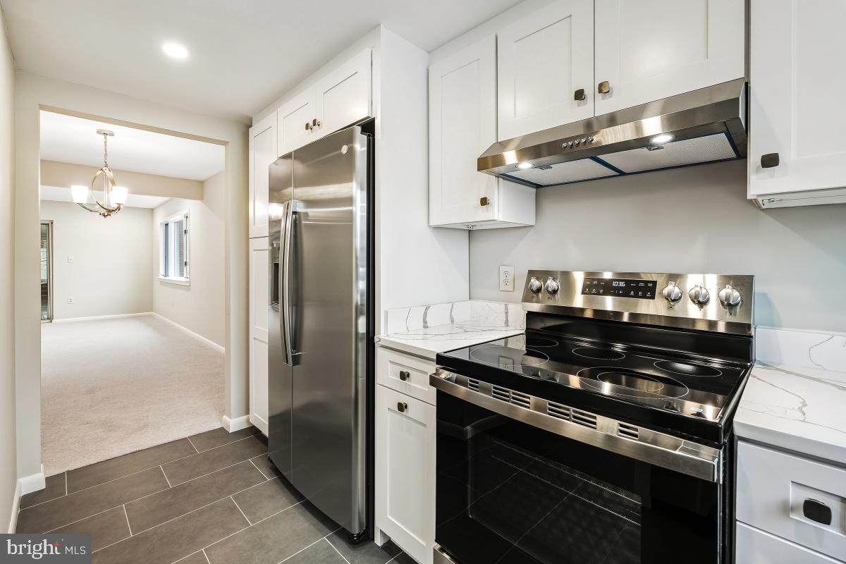 3436 Chiswick Court, Unit 45H Silver Spring, MD 20906 - Photo 11 of 30 a kitchen with stainless steel appliances granite countertop a stove a refrigerator and a microwave