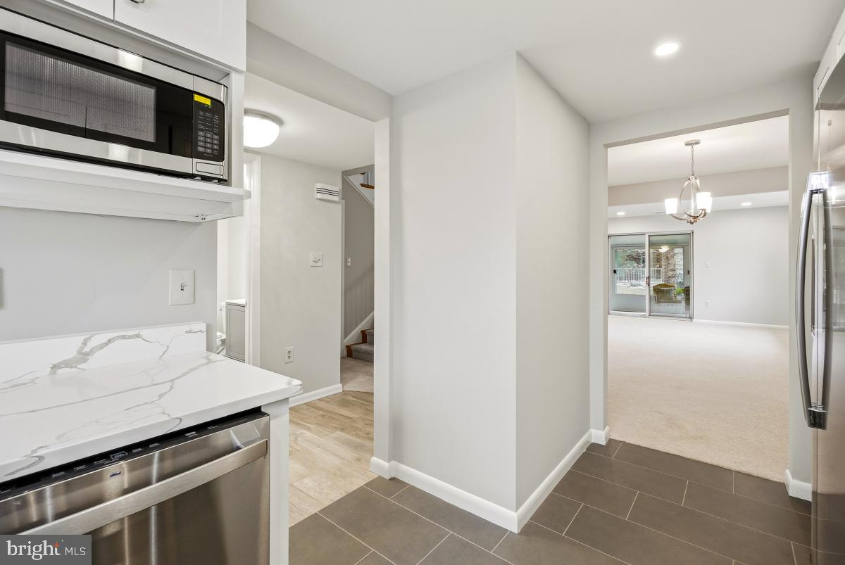 3436 Chiswick Court, Unit 45H Silver Spring, MD 20906 - Photo 10 of 30 a kitchen with stainless steel appliances kitchen island granite countertop a refrigerator and a sink