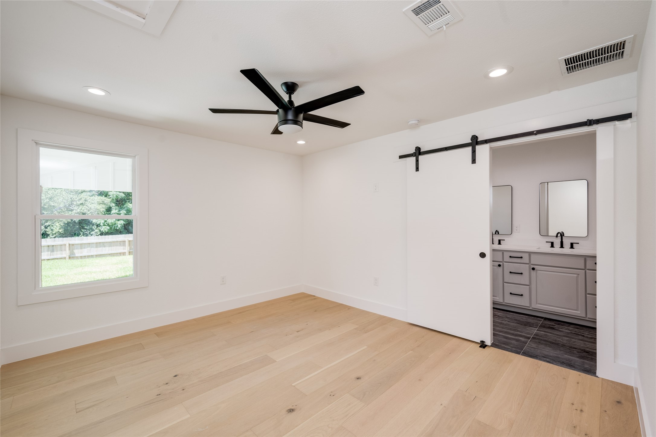 1928 Miles Avenue, Unit 1 Austin, TX 78745 - Photo 14 of 28 a view of a big room with wooden floor a ceiling fan and windows