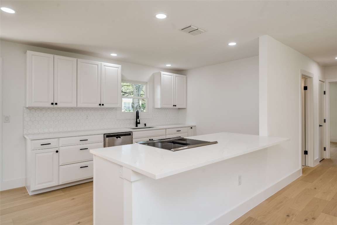 1928 Miles Avenue, Unit 1 Austin, TX 78745 - Photo 9 of 28 a kitchen with a sink a stove a refrigerator and white cabinets