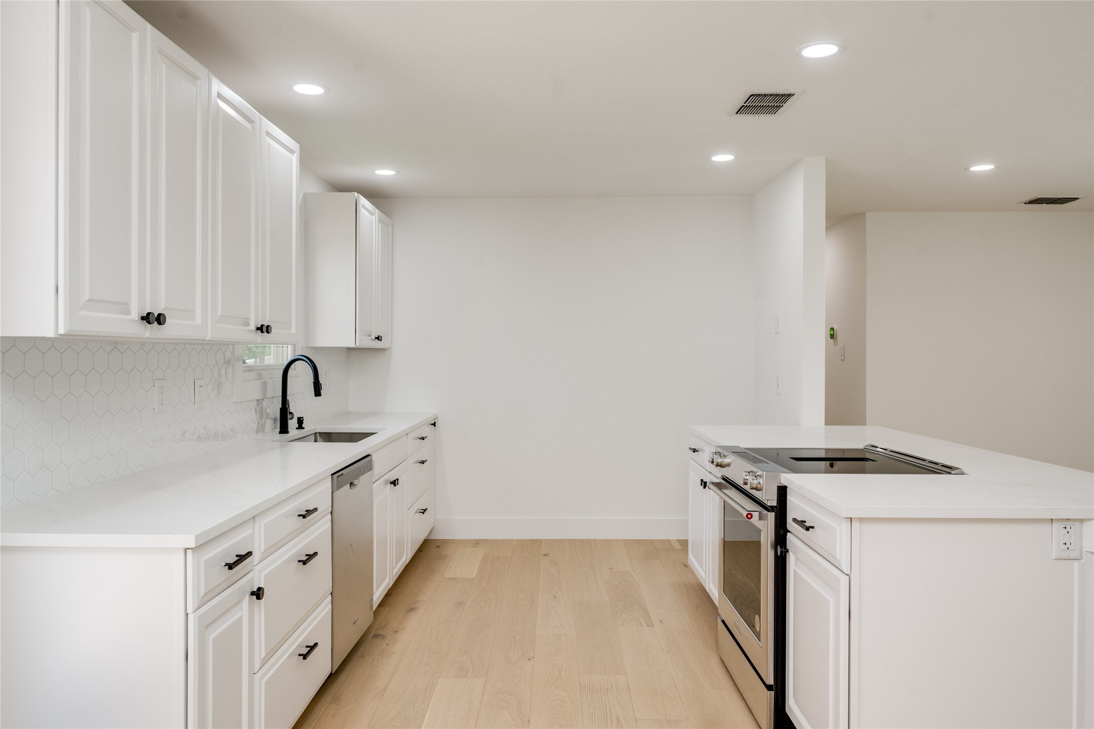 1928 Miles Avenue, Unit 1 Austin, TX 78745 - Photo 10 of 28 a kitchen with granite countertop a sink stove and cabinets