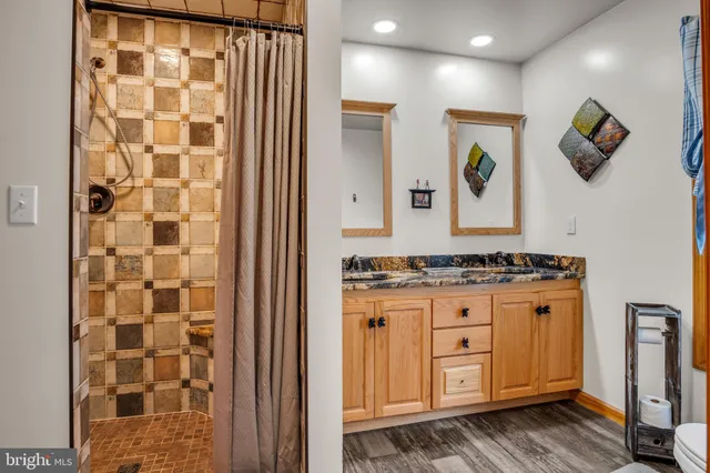 a bathroom with a granite countertop sink and a shower