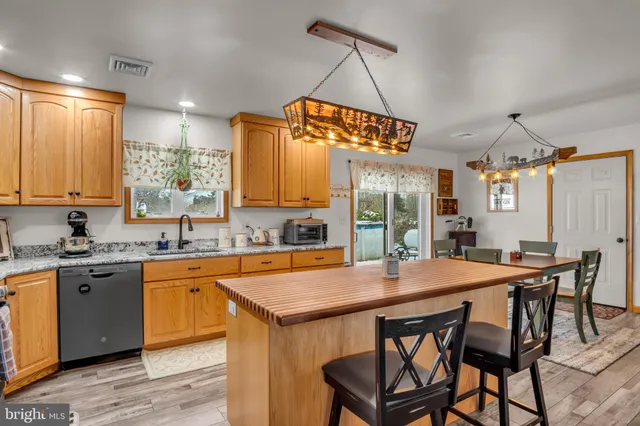 a kitchen with stainless steel appliances granite countertop a kitchen island a stove and a refrigerator